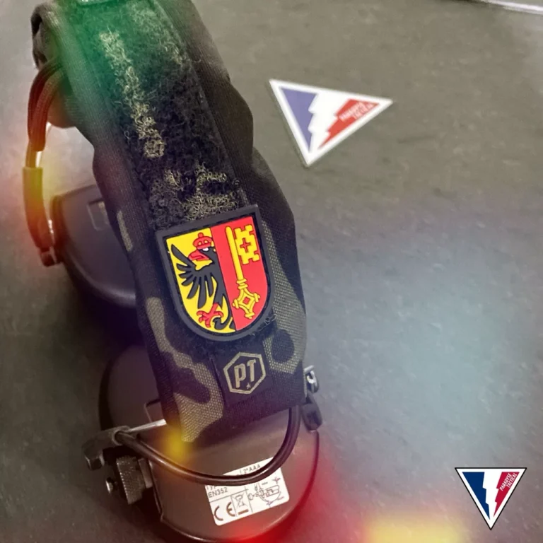 Patch Security Division aux couleurs de Genève sur un équipement vert.