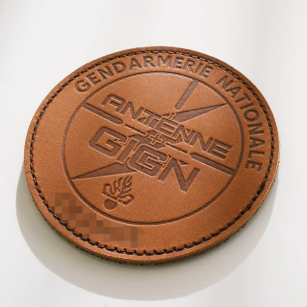 Patch rond en cuir brun gravé pour l’antenne GIGN d’Orange.