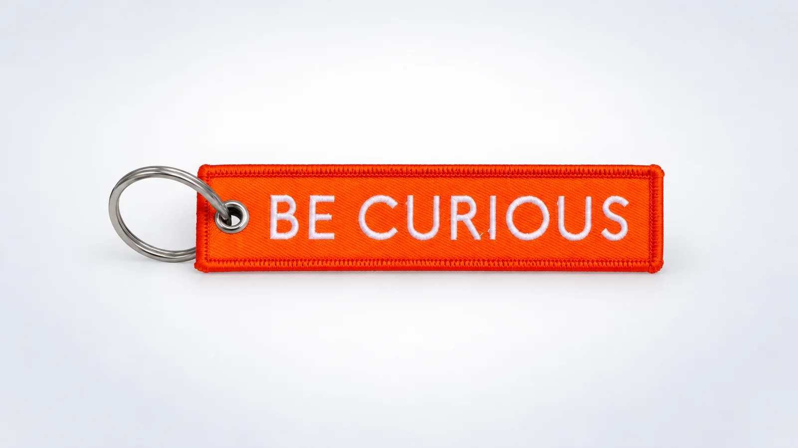 Porte-clés flamme orange brodé avec inscription blanche BE CURIOUS
